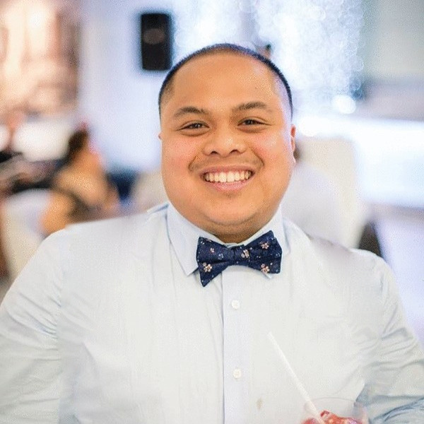 Matt Hernando, smiling, in a light blue shirt and navy bow tie